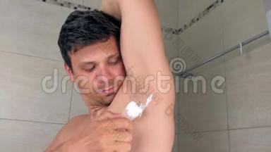 卫生间用抹刀在腋窝涂抹脱毛膏的人的肖像。